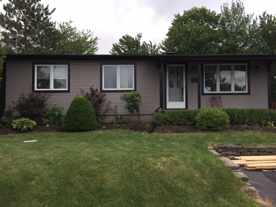 Une maison avec une grande pelouse devant elle