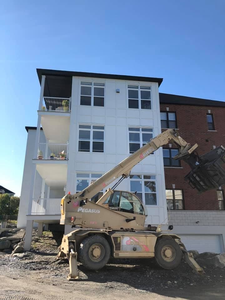 Un grand bâtiment avec un chariot élévateur devant