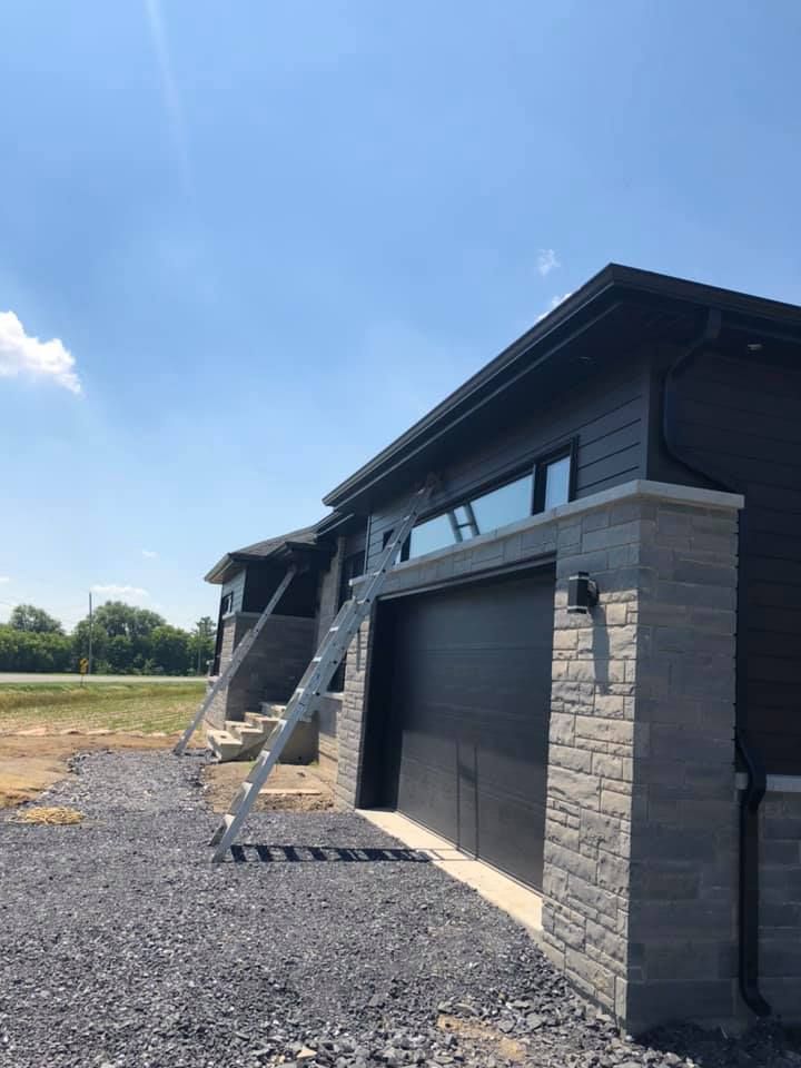 Une maison avec un garage et des escaliers sur le côté.