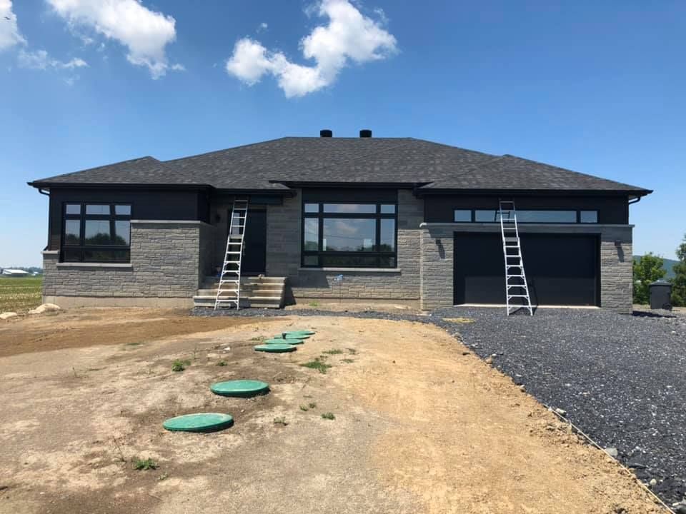 Une grande maison avec une échelle devant elle est en construction.