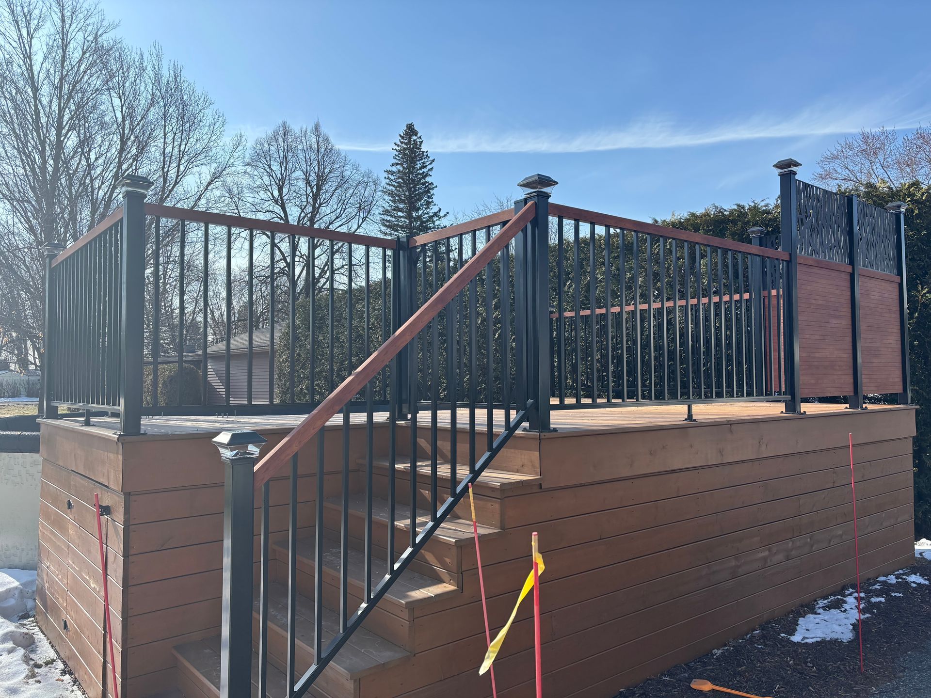 Une terrasse en bois avec des escaliers et une rampe en métal