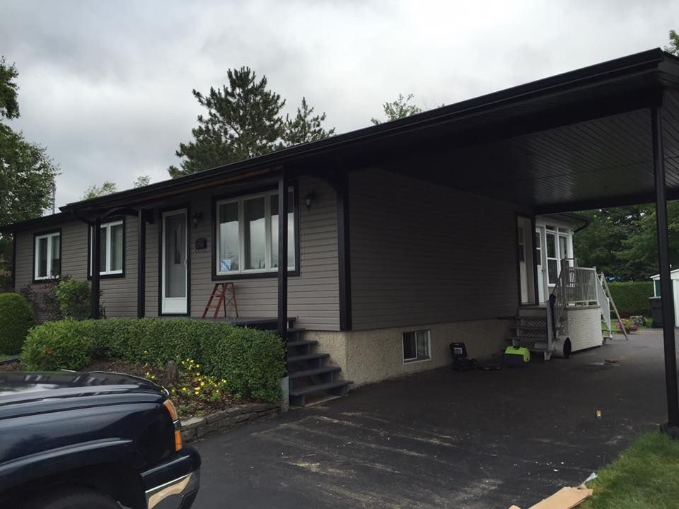 Un camion noir est garé devant une maison