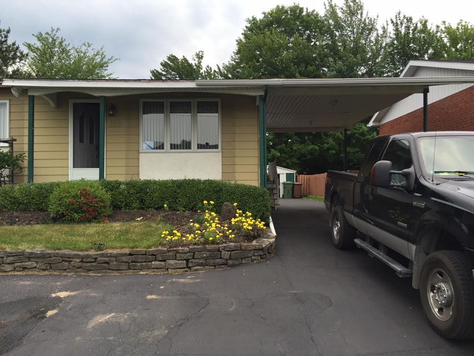 Un camion noir est garé devant une maison