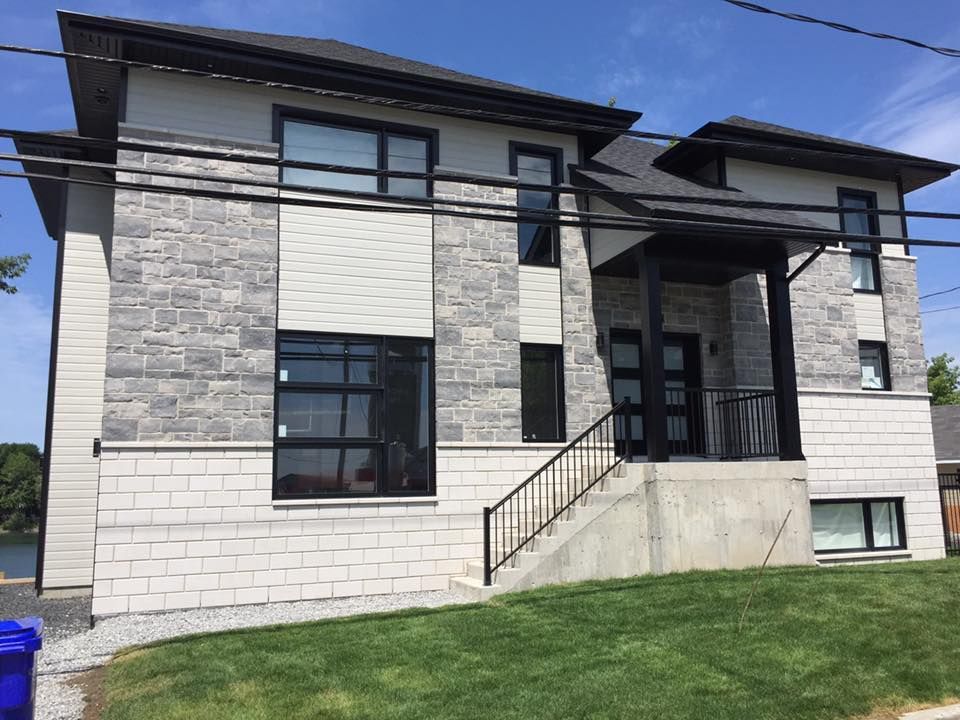 Une grande maison en briques avec des escaliers menant à la porte d'entrée.