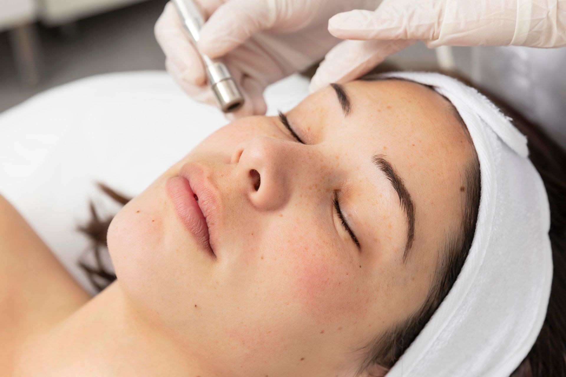 A woman is getting a facial treatment at a beauty salon.