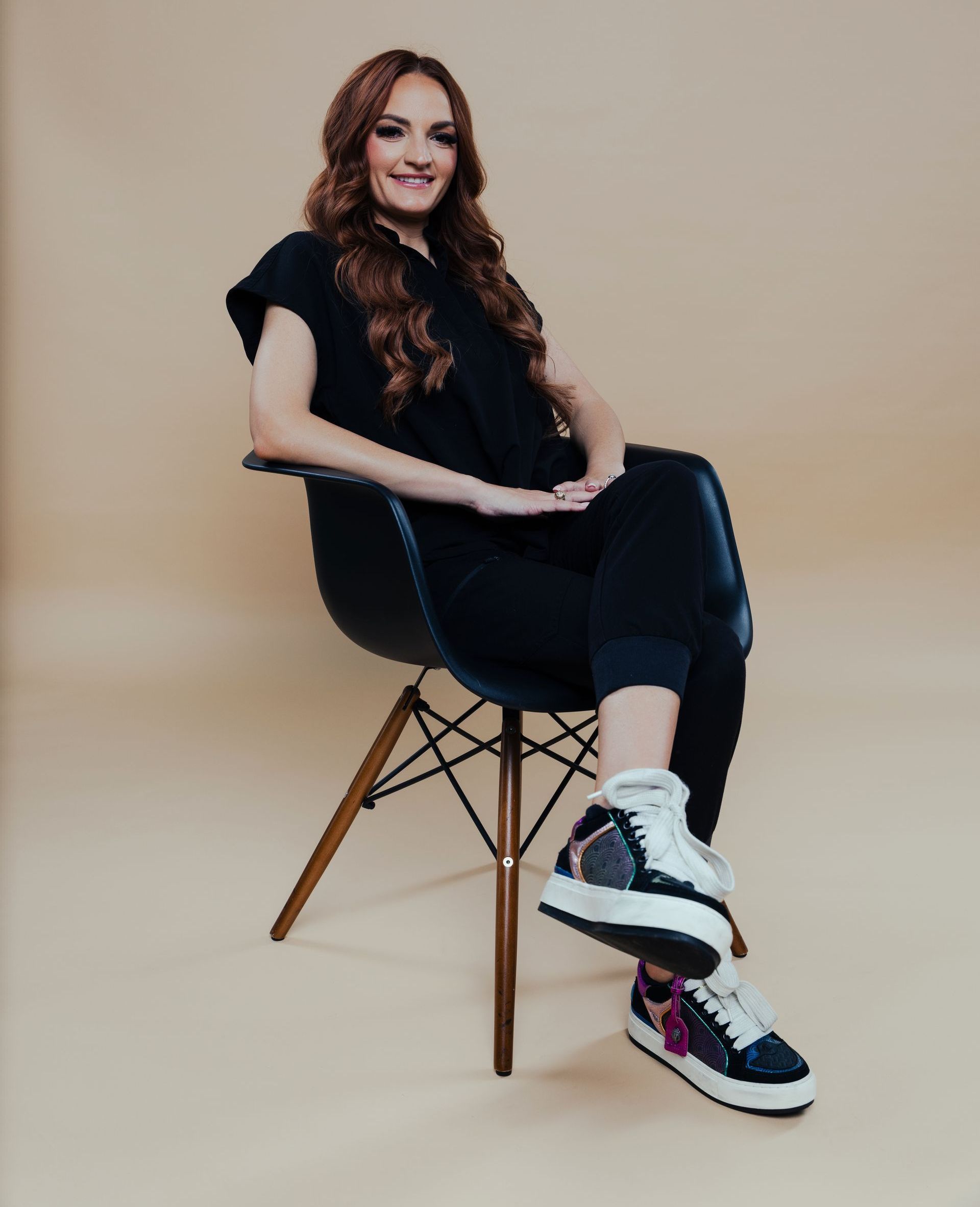 A woman is sitting in a chair with her legs crossed.