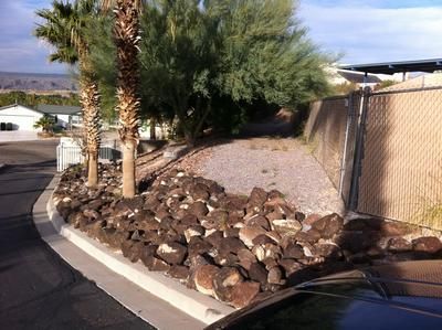 A car is parked on the side of the road next to a rock wall