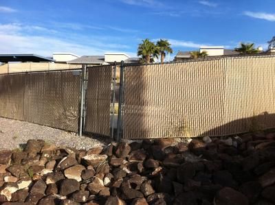 A chain link fence is surrounded by rocks and a gate.