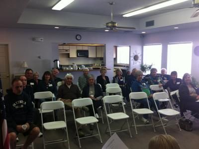 A group of people are sitting in folding chairs in a room