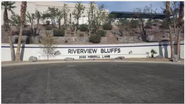 A sign that says riverview bluffs is on the side of a road.