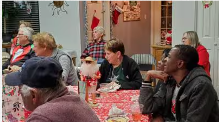 A group of people are sitting at a table in a room.