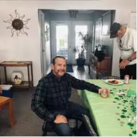 A man is sitting at a table with a plate of food.