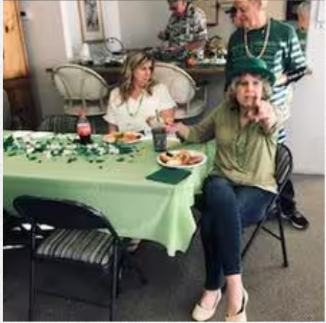A group of people are sitting at a table with plates of food.