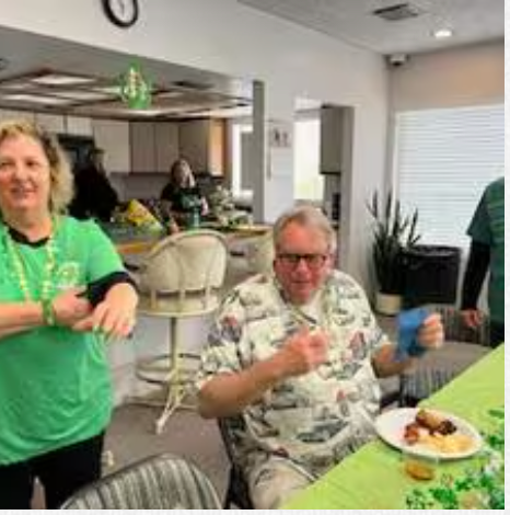 A group of people are sitting at a table with plates of food.