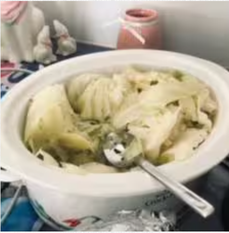 A bowl of food with a spoon in it on a table.