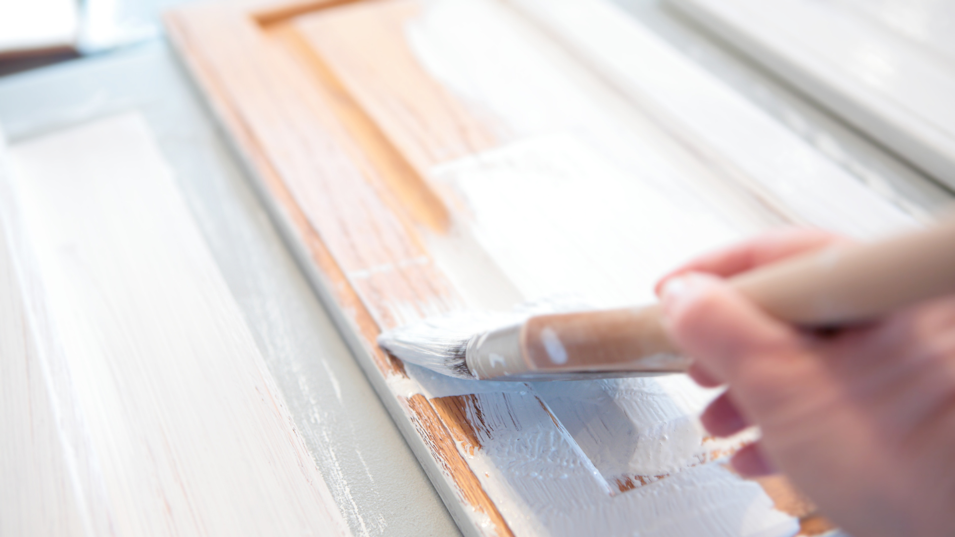A person is painting a piece of wood with a brush.