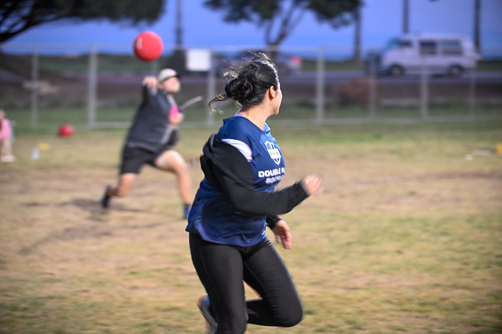 Baseball player sliding into base as another player attempts to catch the ball.