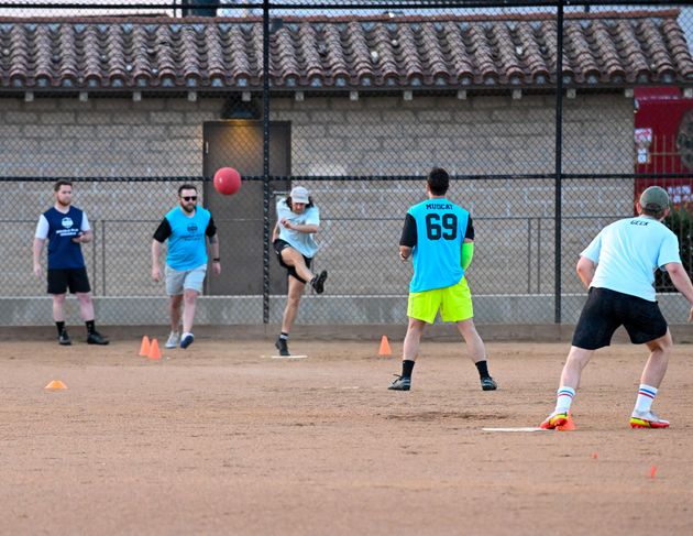 Baseball player sliding into home plate, catcher in front. Blue and gold uniforms, action shot.