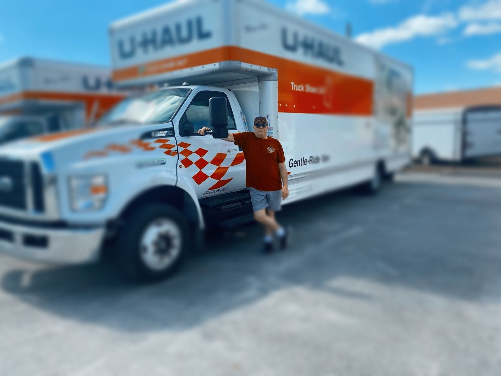 a man is standing in front of a u-haul truck .
