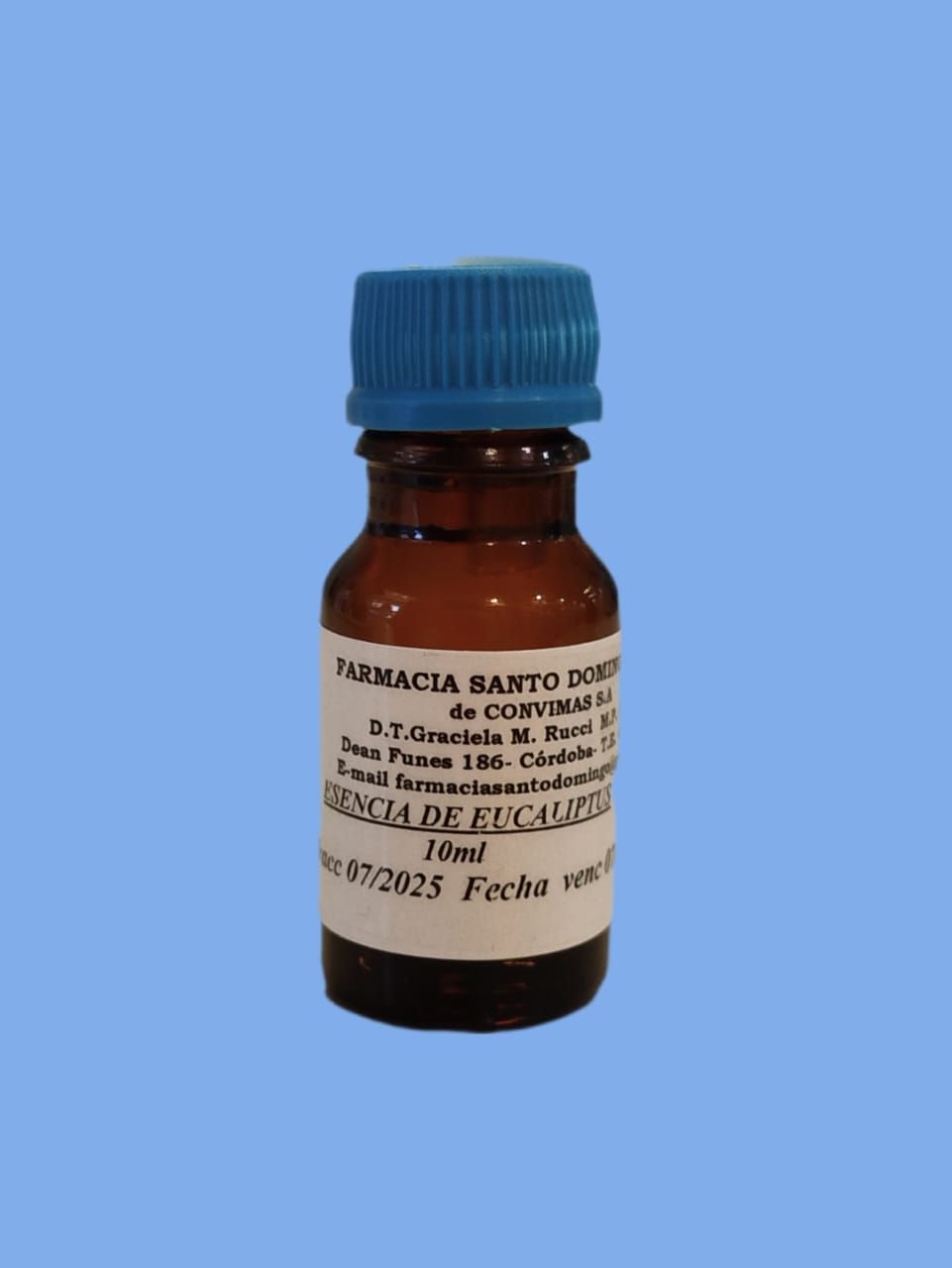 Una pequeña botella de color ámbar con una tapa azul, etiquetada "Esencia de Eucalipto" y otro texto, sobre un fondo azul.