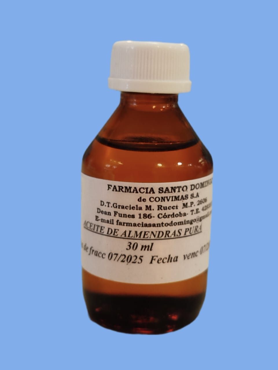 Una botella de vidrio marrón de "Aceite de Almendras Pura" con tapón y etiqueta blancos sobre fondo azul.