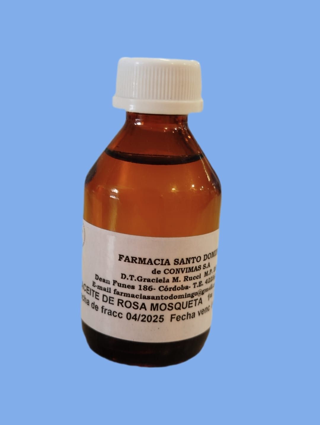 Una botella de líquido de color ámbar con tapa blanca, etiquetada "Farmacia Santo Domingo" y "Aceite de Rosa Mosqueta".