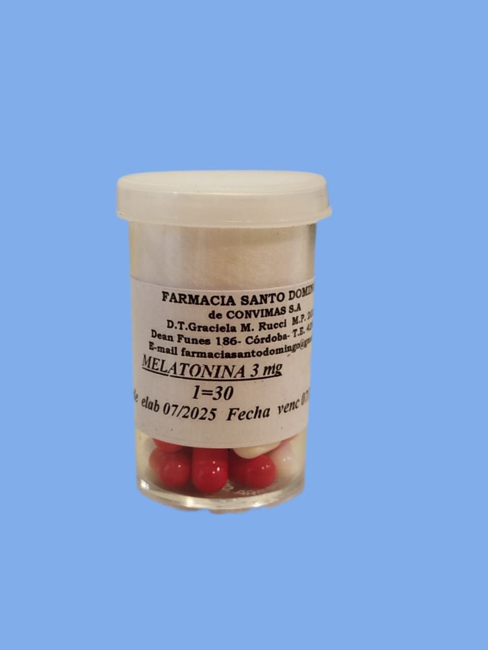 Un pequeño envase de plástico transparente con cápsulas rojas y blancas etiquetadas como "Melatonina 3 mg".