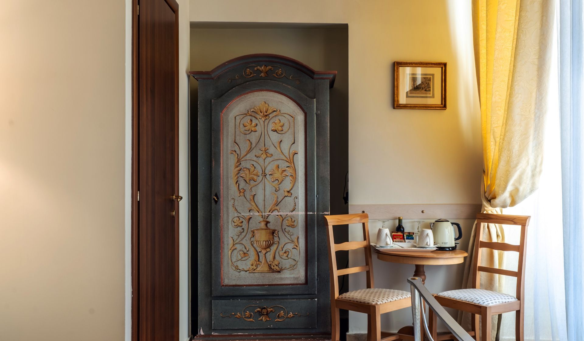 A room with a table and chairs and a wardrobe