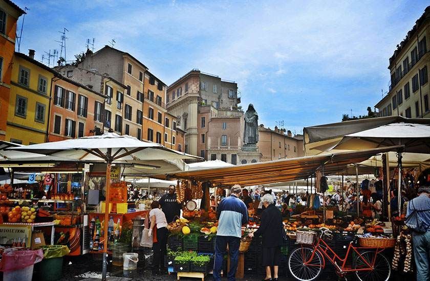 Un gruppo di persone sta facendo la spesa in un mercato in una città.