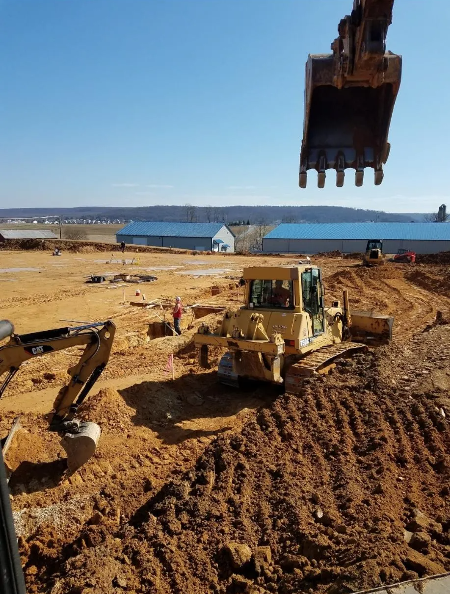 A bulldozer is digging a hole in the dirt on a construction site.