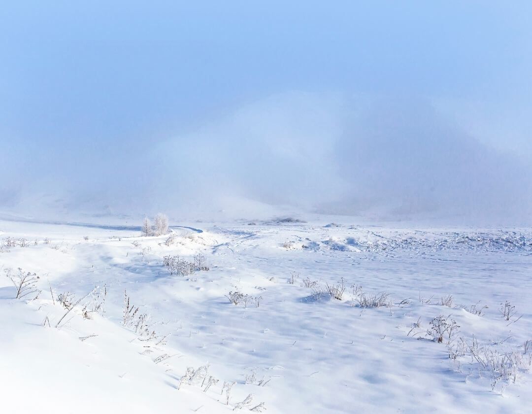 frozen desert landscape with snowy ground and blue sky