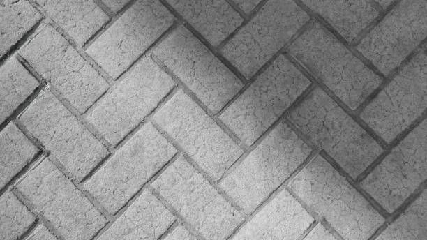 Zigzag brick pavement with herringbone pattern and shadow detail.