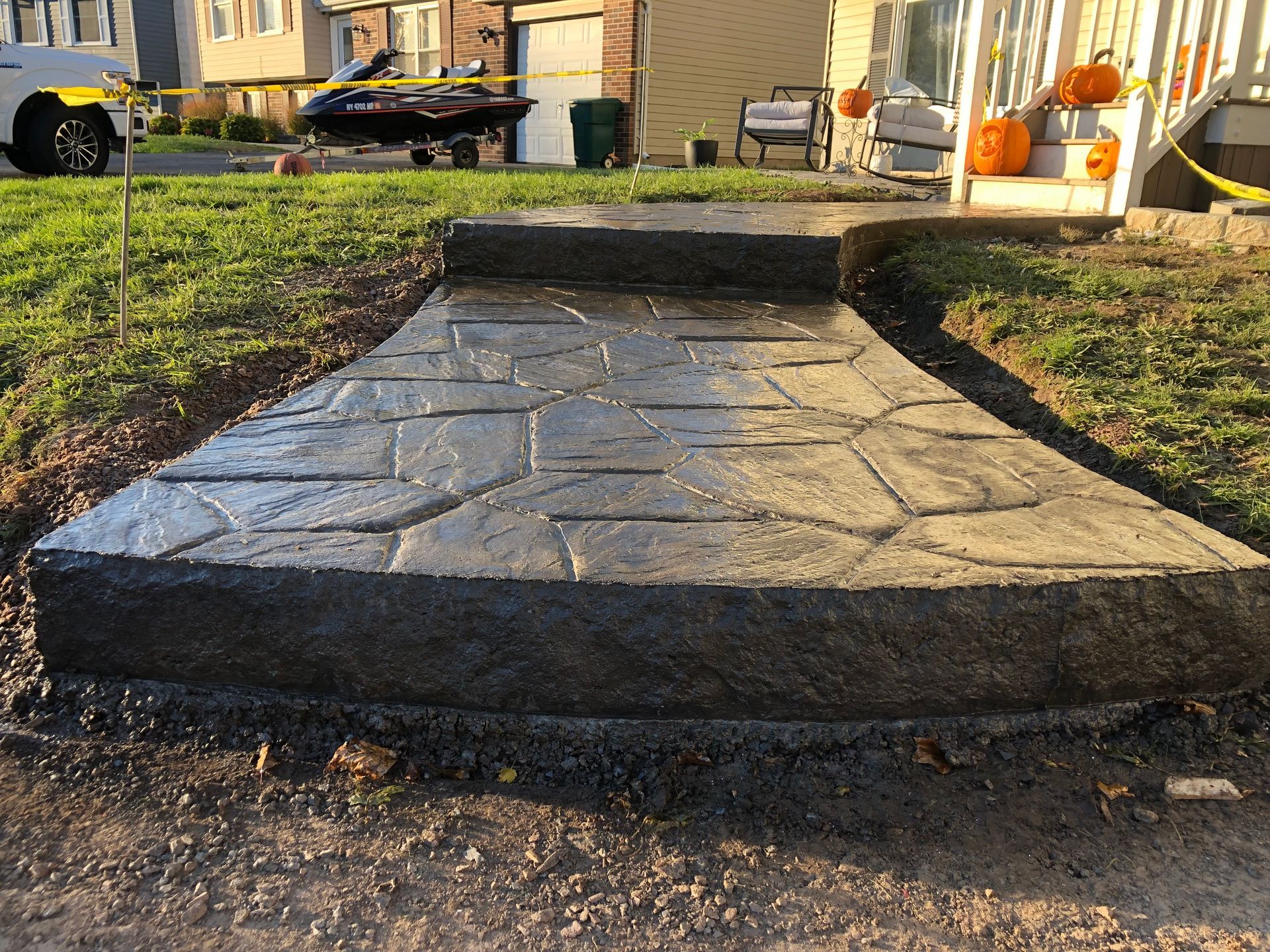 Newly poured concrete walkway with stone pattern.