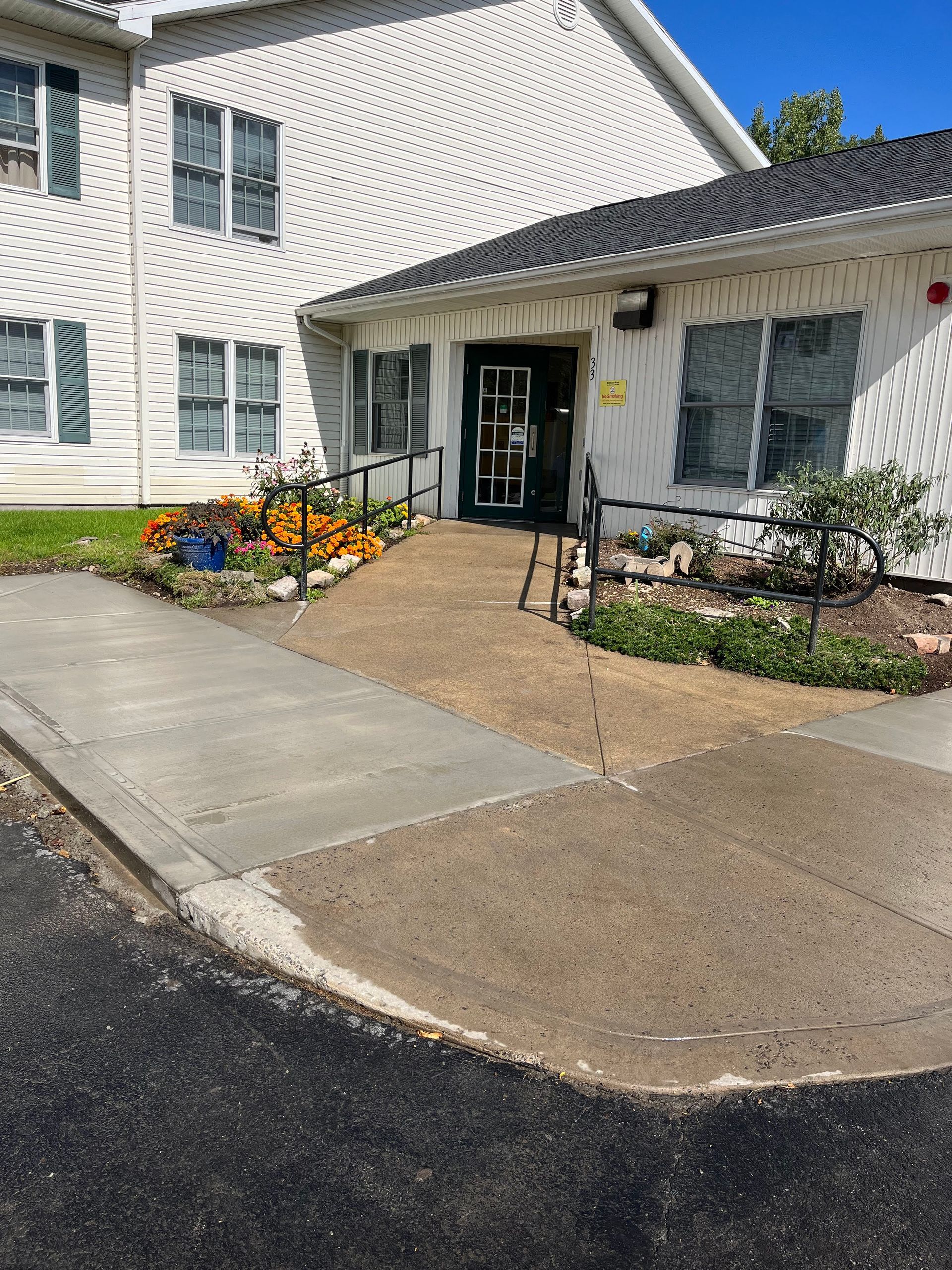Building entrance with accessible ramp and seasonal pumpkins.