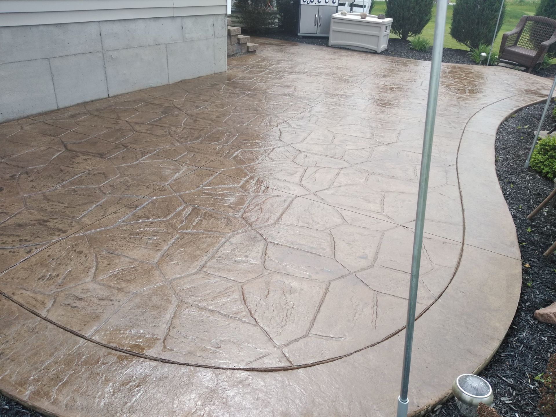 Stamped concrete patio with fieldstone pattern and stone border in Syracuse NY