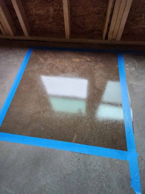 A concrete floor with a blue tape around it.