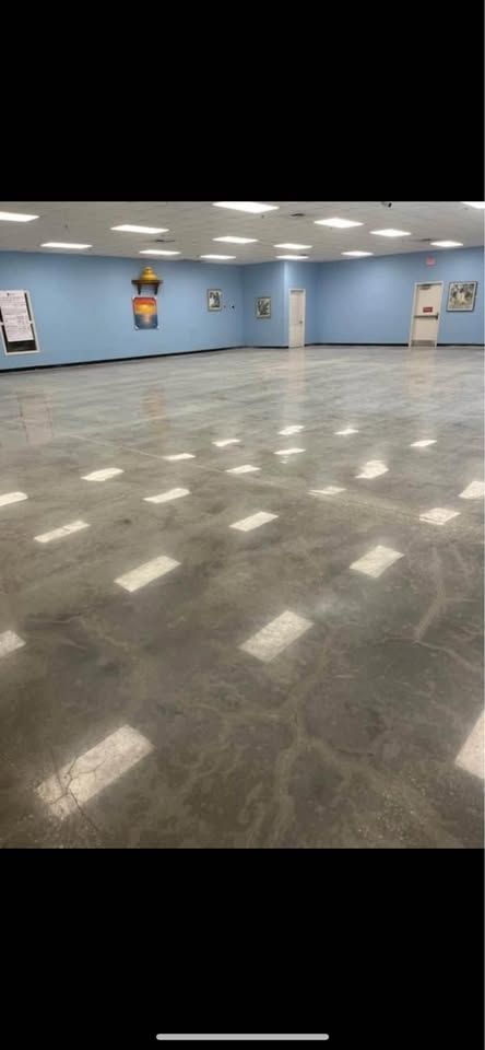 A large empty room with a concrete floor and blue walls.