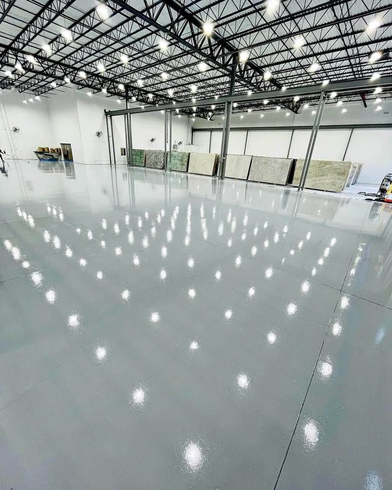 A large warehouse with a lot of lights on the ceiling and floor.