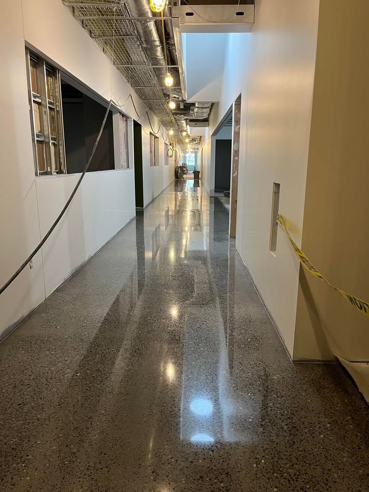 A long hallway in a building with a shiny concrete floor.