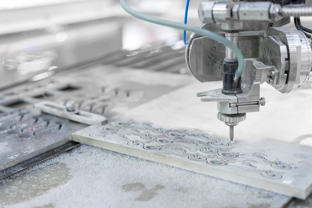 A Machine is Cutting a Piece of Tile With Water — NQBC Pty Ltd in Bowen, QLD