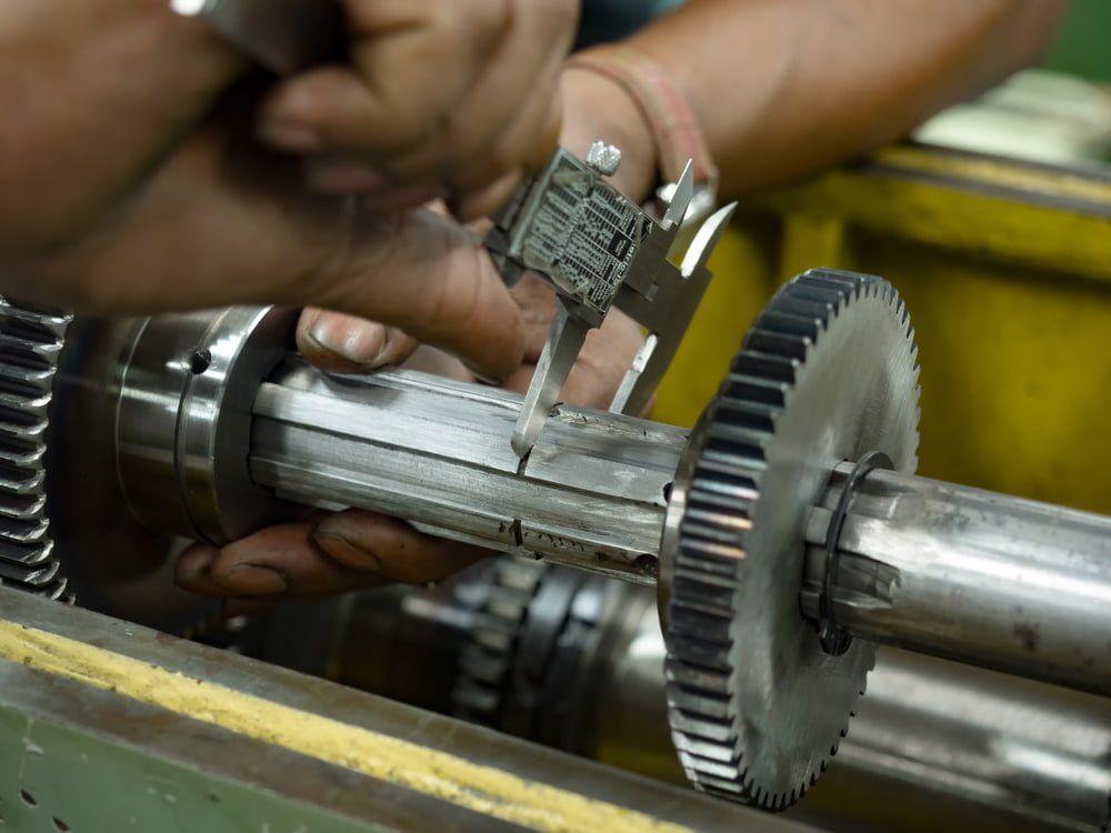A Person is Measuring a Gear With a Digital Caliper — NQBC Pty Ltd in Bowen, QLD