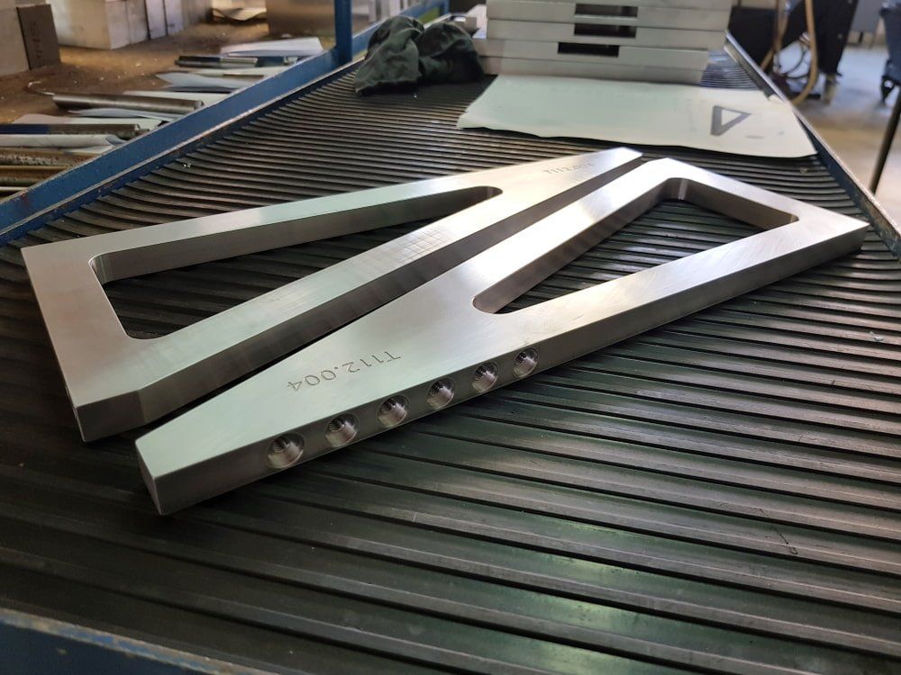 Two Pieces of Metal Are Sitting on a Conveyor Belt — NQBC Pty Ltd in Proserpine, QLD