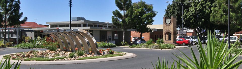 A Roundabout in a City With a Clock Tower in the Background — NQBC Pty Ltd in Emerald, QLD