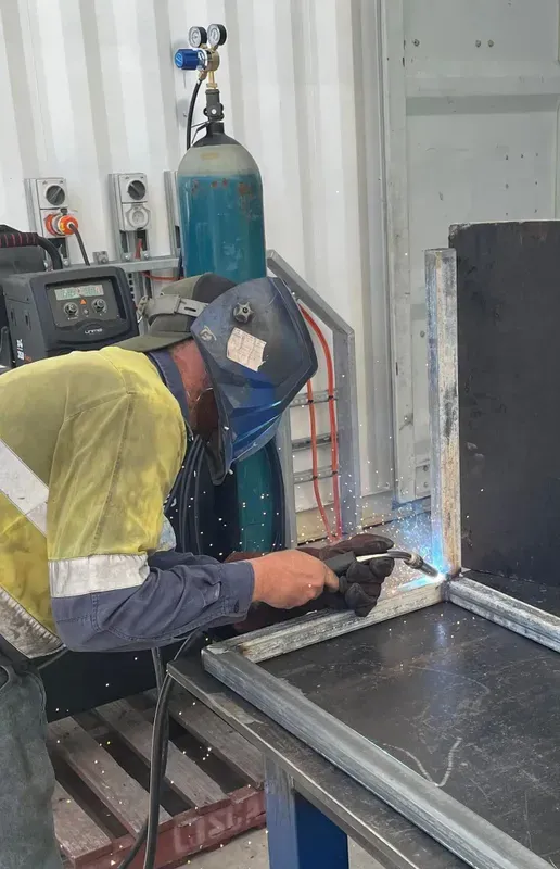 A Man is Welding a Piece of Metal in a Factory — NQBC Pty Ltd in Bowen, QLD