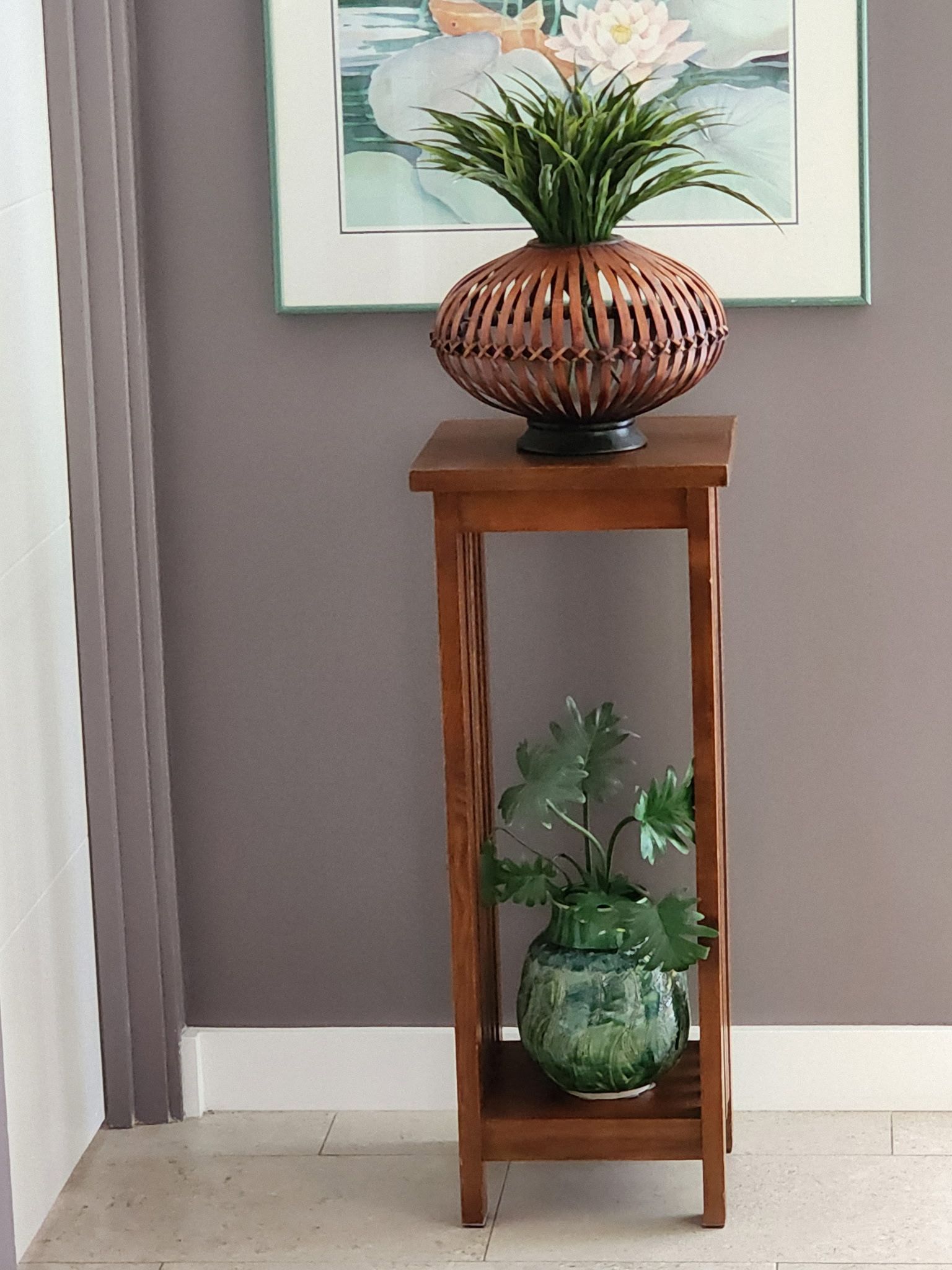 Wooden plant stand with two decorative pots.  One holds a plant with green leaves, the other a plant with brown leaves.