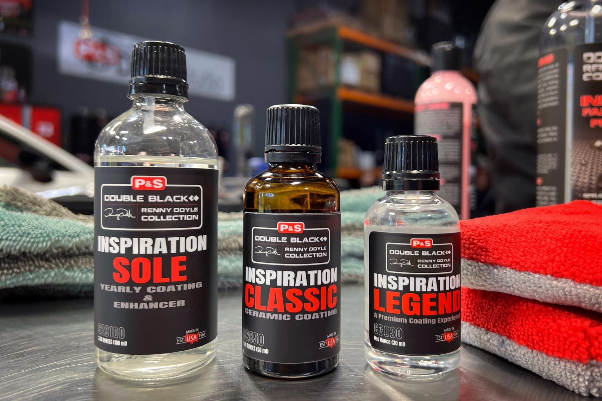 Three bottles of car detailing products: Inspiration Sole, Classic, and Legend, displayed on a table.