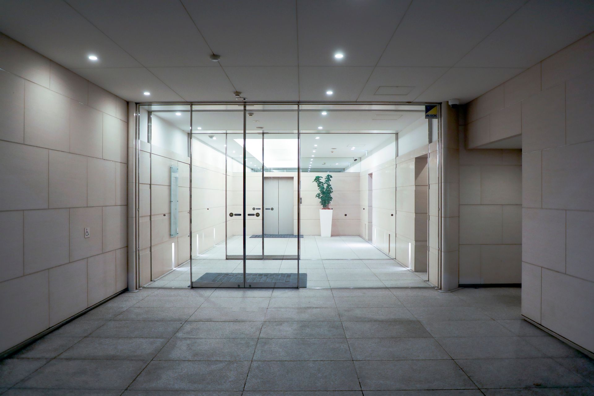 An Empty Lobby with A Glass Door and A Plant in A Pot — Charleston, SC — Charleston Glass Co