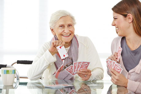 old woman playing cards with young woman