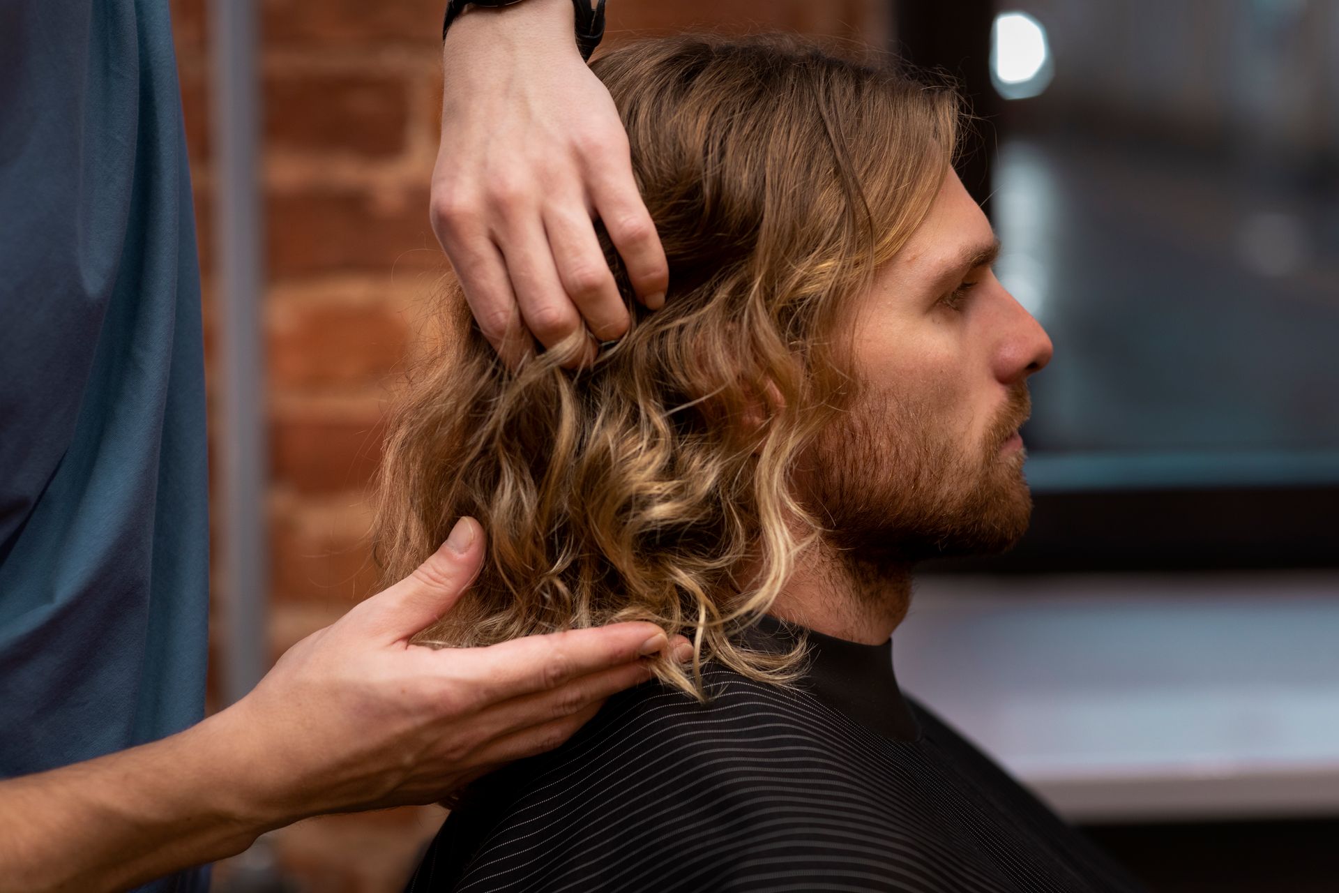 A man is getting his hair cut by a barber in a barber shop.