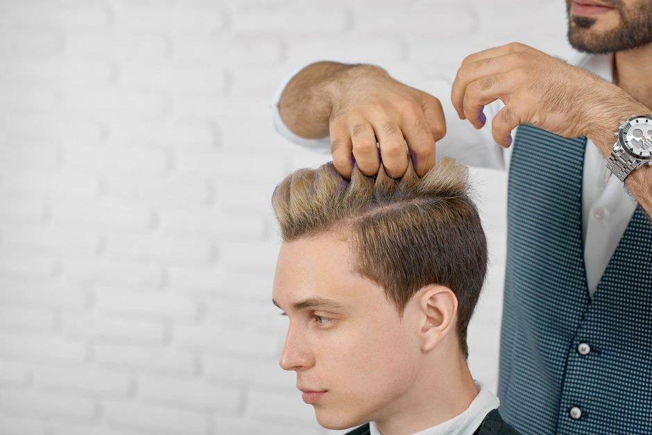 A man is getting his hair cut by a barber.